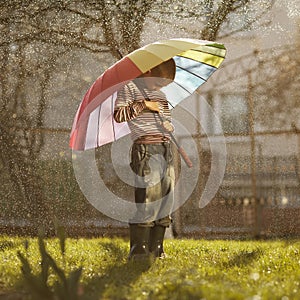 Sad boy with colorful rainbow umbrella