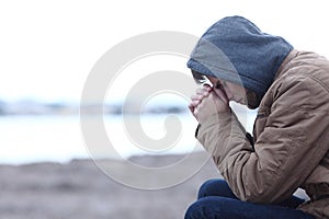 Sad boy complaining in winter on the beach