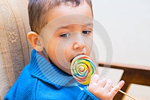 Sad boy eating Lollipop