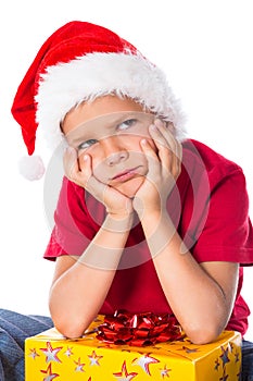 Sad boy with gift box in christmas hat