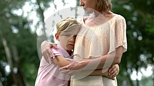 Sad boy hugging mother, bereavement of family member, psychological trauma