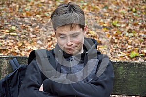 Sad boy resting on a bench