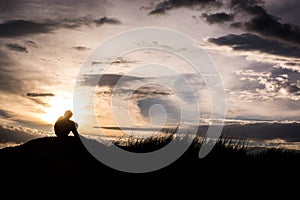 Sad boy silhouette worried on the meadow at sunset ,Silhouette c