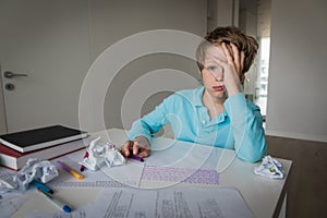 Sad boy tired and stressed of learning, doing homework