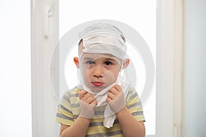 Sad boy wearing many medicine masks, quarantine at home, virus protection