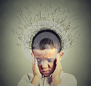 Sad boy with worried stressed face expression looking down