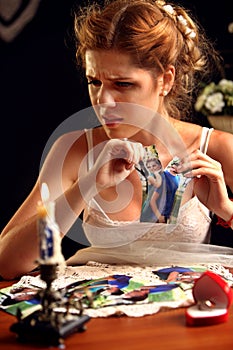 Sad bride on unhappy wedding. Portrait girl tearing family pictures.