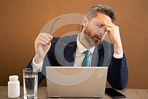 Sad business man having a terrible headache. Exhausted man feeling unhealthy, upset about headache illness. Stressed