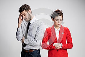 The sad business man and woman conflicting on a gray background