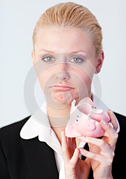 Sad business woman with broken piggybank photo