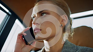 Sad business woman talking mobile phone. Upset girl sitting with phone at car