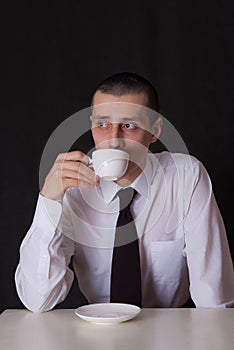 Sad businessman drinking coffee