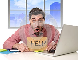 Sad businessman at office desk working on computer laptop asking for help depressed
