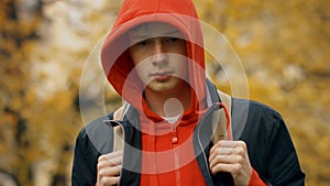 Sad caucasian teenager boy with backpck outdoors in autumn park