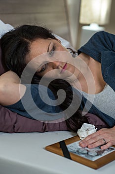 Sad Caucasian widow lying in bed