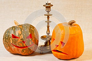 Sad and cheerful halloween pumpkin with candle