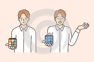 Sad and cheerful man holding Rubiks cube trying to assemble logic toy by solving puzzle photo