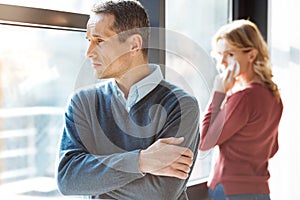 Sad cheerless man standing cross handed