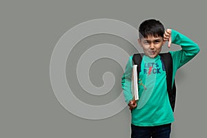 Sad child boy with books in hand and bag on shoulders, hate study concept copy space