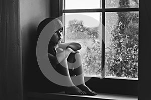 Sad child, boy, sitting on a window shield