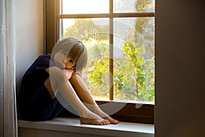 Sad child, boy, sitting on a window shield