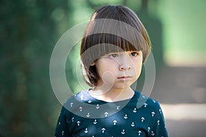 Sad child face portrait on blurry background