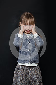 Sad child girl crying on black background
