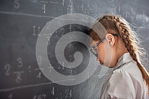 Sad child near the blackboard