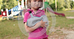 Sad child outdoors with a broken limb small, injured boy.