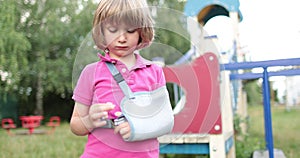 Sad child outdoors with a broken limb small, injured boy.