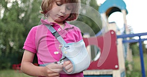 Sad child outdoors with a broken limb small, injured boy.