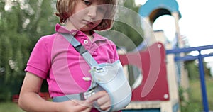 Sad child outdoors with a broken limb small, injured boy.