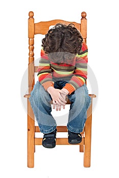 Sad child sitting on a chair isolated