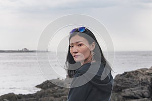 Sad Chinese woman on the Maine coast