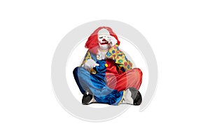 A sad clown sitting on the floor and crying