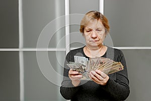 sad concentrated elderly woman counting banknotes in her hands, SHOTLISTbanking,