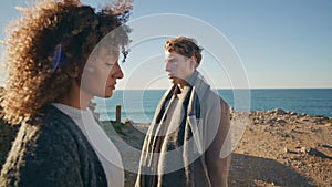 Sad couple posing ocean cliff closeup. Curly woman blonde man feeling upset