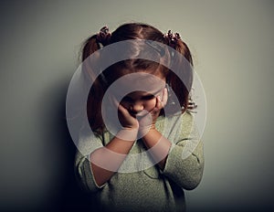 Sad crying alone kid girl on dark background