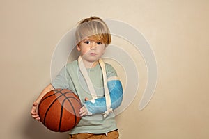 Sad crying little blond boy with basketball ball