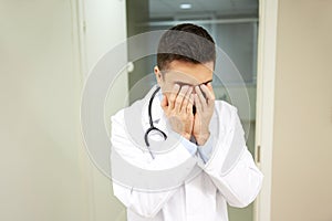 Sad or crying male doctor at hospital ward