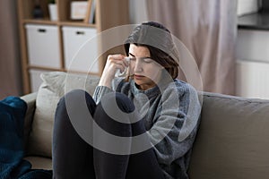 sad crying woman sitting on sofa at home