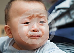 Sad cute asian baby watching out