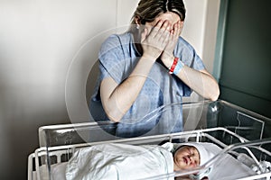 Sad and depress Mother with her newborn baby at the hospital a day after a natural birth labor