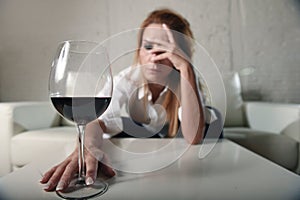 Sad depressed alcoholic drunk woman drinking at home in housewife alcohol abuse and alcoholism