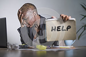 Sad and depressed black afro American woman suffering stressed at office working with laptop computer feeling overwhelmed asking f