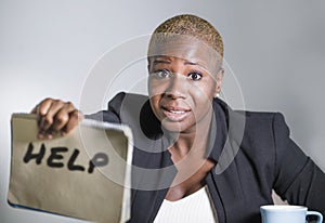 Sad and depressed black afro American woman suffering stressed at office working with laptop computer feeling overwhelmed asking f