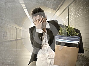 Sad depressed businesswoman carrying cardboard box fired from Job