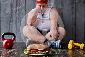 Sad depressed fat guy wants to eat during sport exercises
