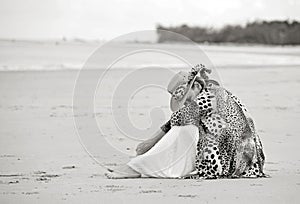 Sad depressed grieving woman sitting alone on empty beach