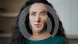 Sad depressed woman arab hispanic upset wife stand alone in kitchen looking at camera with resentful offended facial